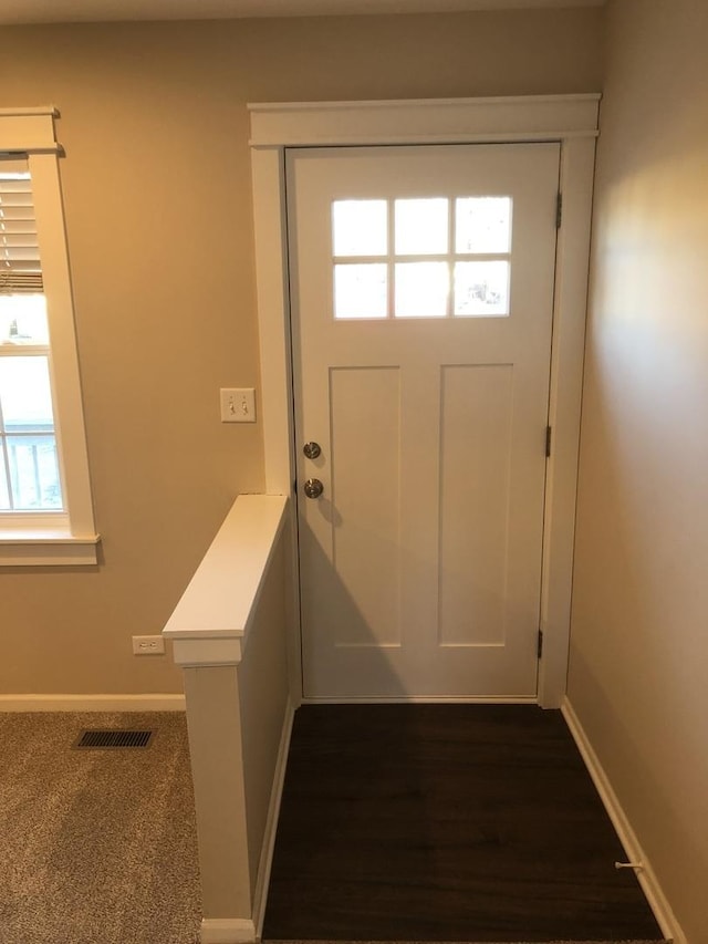 doorway to outside with dark colored carpet