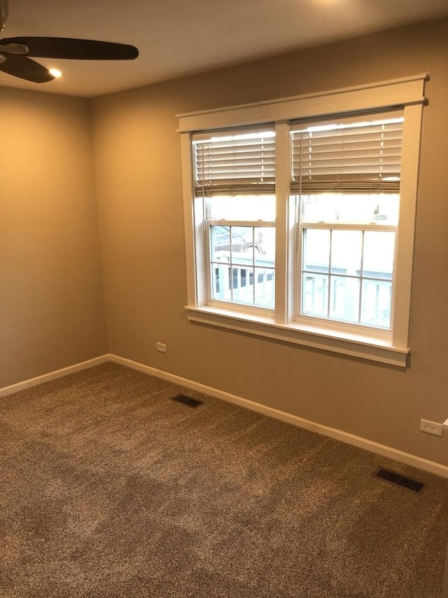 carpeted empty room featuring ceiling fan