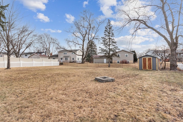 view of yard featuring a storage shed and an outdoor fire pit