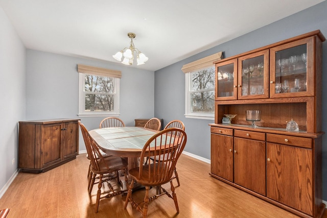 dining space featuring light hardwood / wood-style flooring, a chandelier, and a healthy amount of sunlight