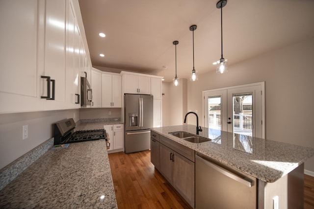 kitchen featuring white cabinetry, an island with sink, sink, light stone counters, and stainless steel appliances