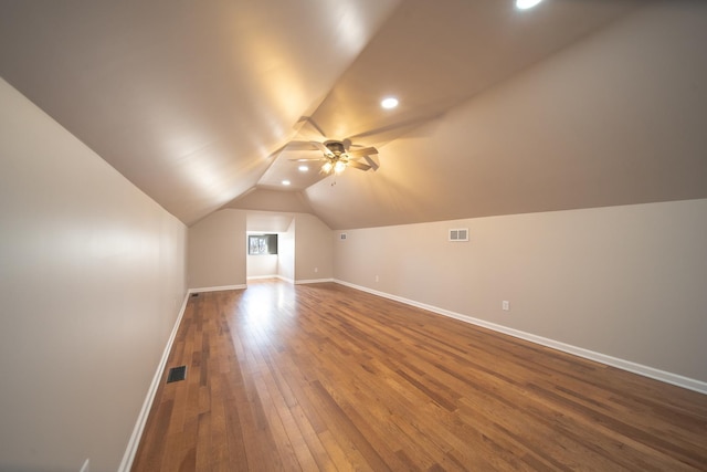 additional living space with wood-type flooring, ceiling fan, and vaulted ceiling