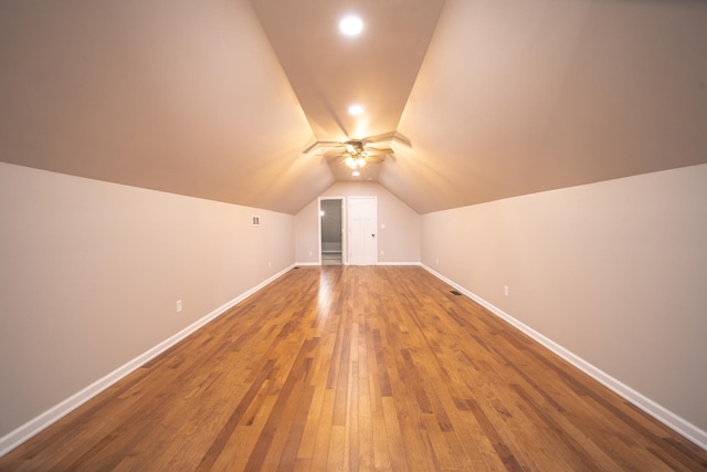 additional living space with hardwood / wood-style flooring and lofted ceiling