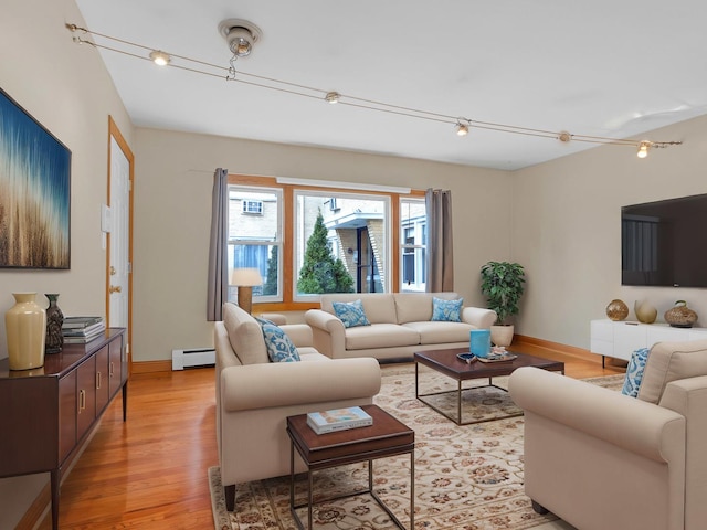 living room with track lighting, light hardwood / wood-style floors, and baseboard heating