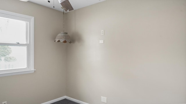 unfurnished room with ceiling fan and carpet