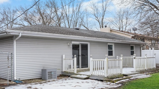 snow covered property featuring a wooden deck and central AC unit