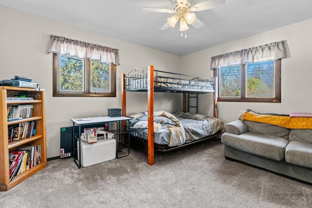 carpeted bedroom with multiple windows and ceiling fan