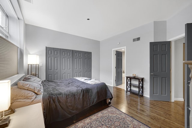 bedroom with dark wood-type flooring and a closet