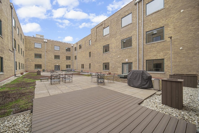 wooden deck featuring a grill and a patio