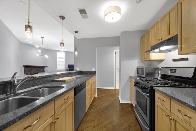 kitchen with sink, dark stone counters, hanging light fixtures, stainless steel appliances, and dark wood-type flooring