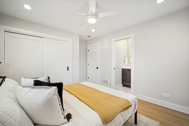 bedroom with ensuite bathroom, a closet, ceiling fan, and light wood-type flooring