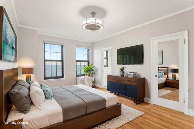 bedroom featuring crown molding and light hardwood / wood-style floors