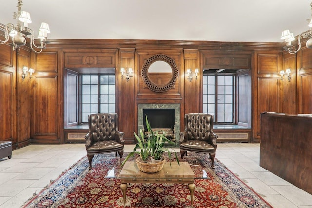 living room featuring a fireplace, an inviting chandelier, and wood walls