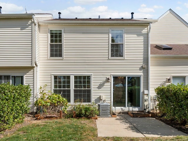 back of property with a patio, cooling unit, and a lawn