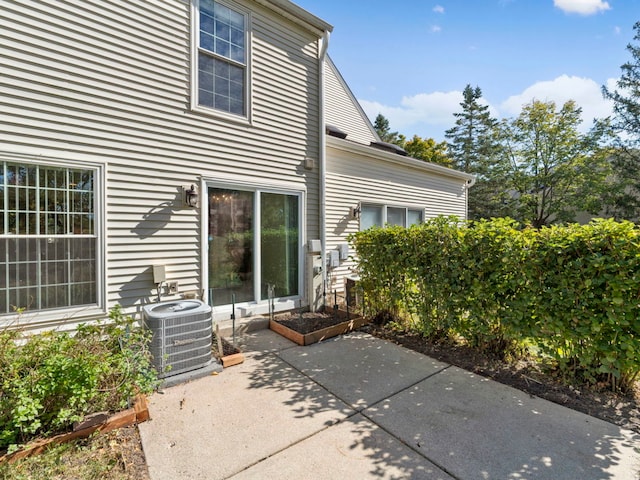 rear view of house with central AC unit and a patio area