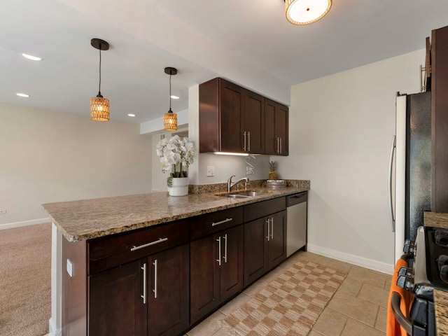 kitchen featuring pendant lighting, sink, kitchen peninsula, stainless steel appliances, and dark brown cabinets