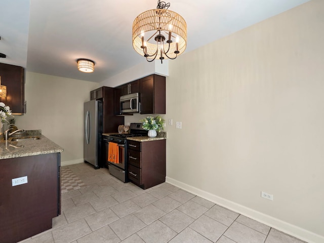 kitchen with sink, hanging light fixtures, stainless steel appliances, a notable chandelier, and light stone countertops