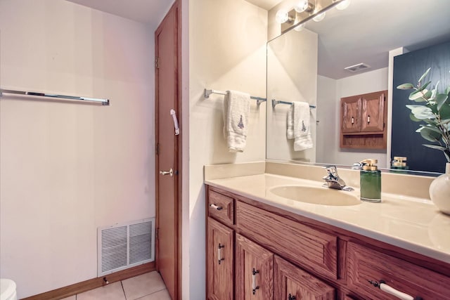 bathroom with tile patterned flooring, vanity, and toilet