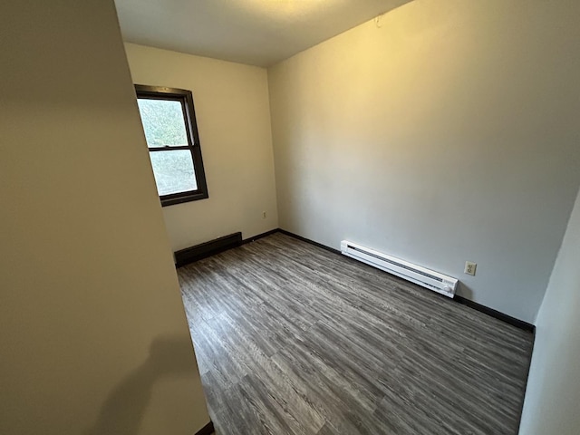 empty room featuring a baseboard radiator and dark hardwood / wood-style floors