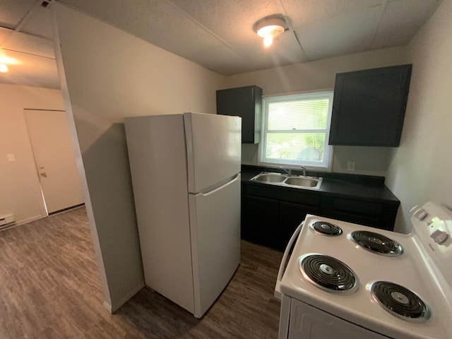 kitchen with sink, white appliances, and dark wood-type flooring