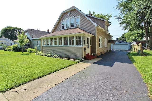 view of front of home featuring an outbuilding, a garage, and a front yard