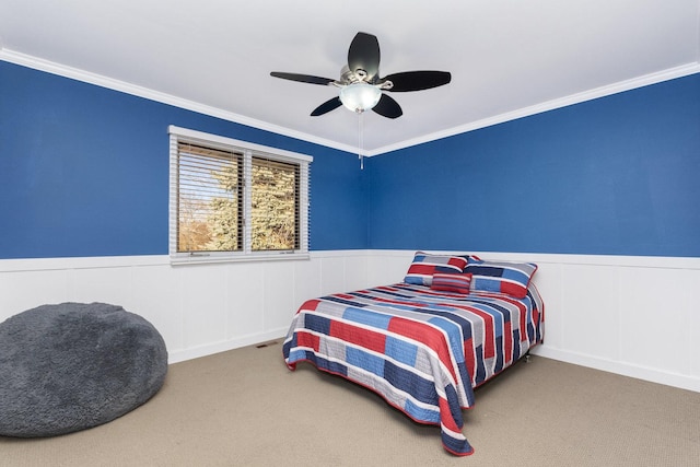 carpeted bedroom with ornamental molding and ceiling fan