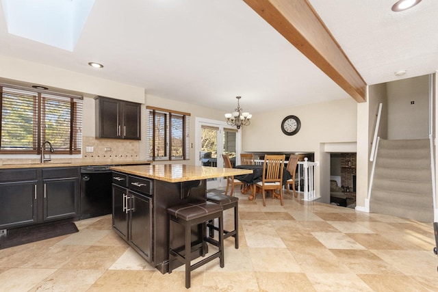 kitchen featuring pendant lighting, dishwasher, a kitchen bar, a center island, and light stone countertops