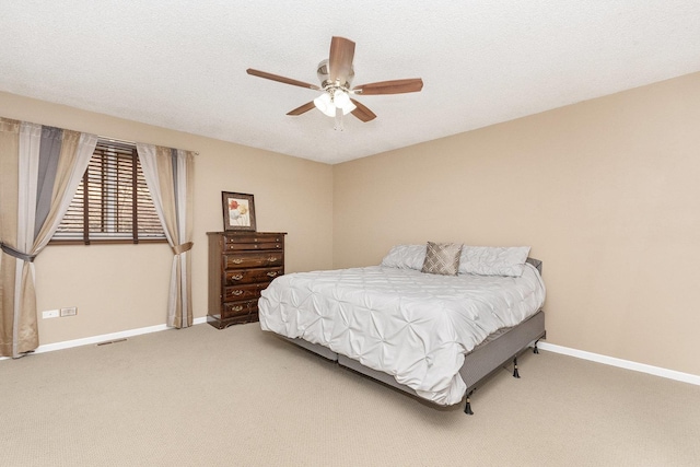 carpeted bedroom featuring ceiling fan and a textured ceiling