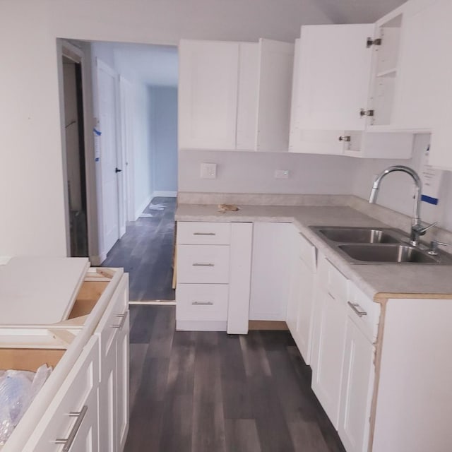 kitchen with dark hardwood / wood-style flooring, sink, and white cabinets