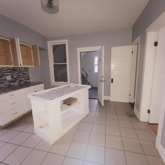 kitchen featuring white cabinetry, light tile patterned floors, and backsplash