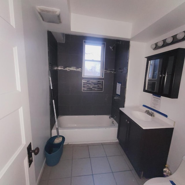 bathroom featuring tile patterned flooring, tiled shower / bath, and vanity