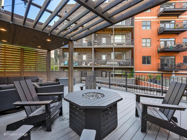 wooden terrace with a pergola and a fire pit