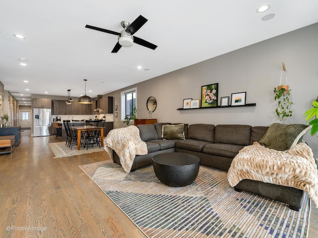 living room featuring ceiling fan, a healthy amount of sunlight, and light hardwood / wood-style floors