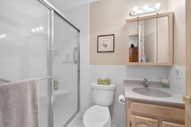 bathroom featuring walk in shower, vanity, toilet, and tile walls