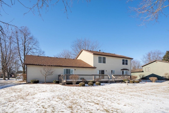 snow covered rear of property featuring a deck