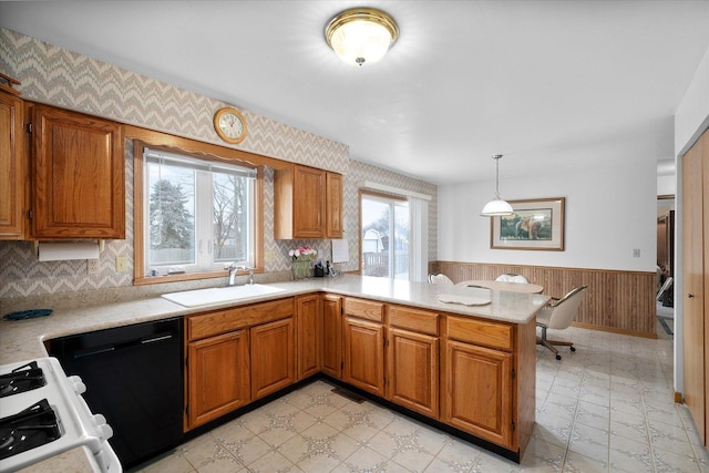 kitchen with black dishwasher, sink, hanging light fixtures, kitchen peninsula, and gas range oven