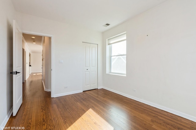 unfurnished bedroom with hardwood / wood-style floors and a closet