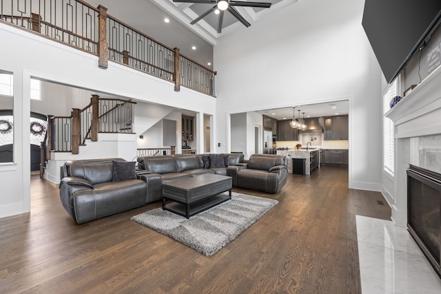 living room featuring a fireplace, dark hardwood / wood-style flooring, ceiling fan with notable chandelier, and a wealth of natural light