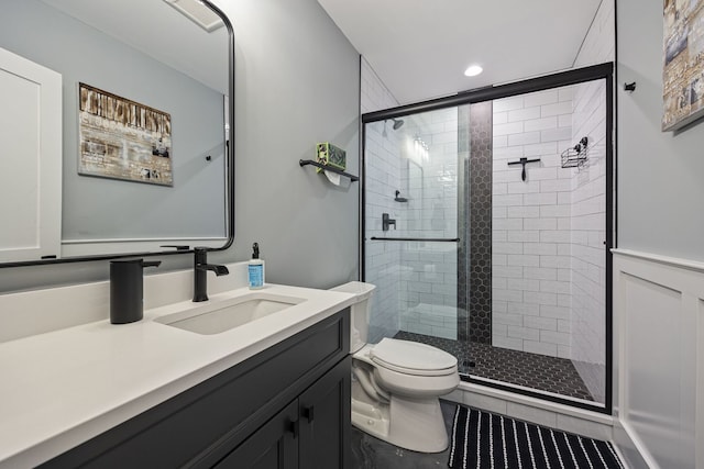 bathroom featuring vanity, a shower with shower door, tile patterned floors, and toilet