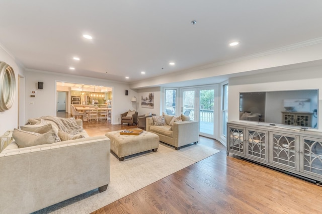 living room featuring crown molding and light wood-type flooring