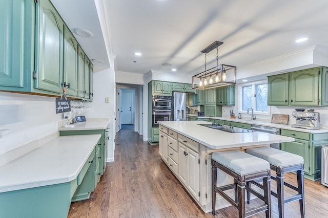 kitchen featuring black electric cooktop, a breakfast bar area, a center island, and green cabinetry