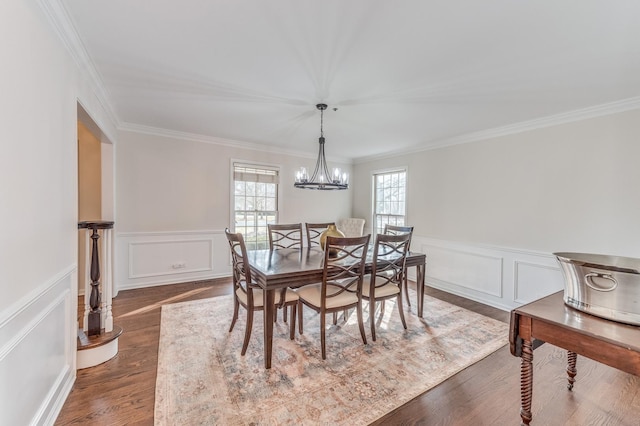 dining area with ornamental molding, dark wood-type flooring, and a notable chandelier