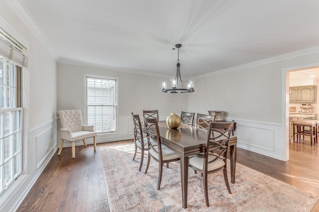 dining room featuring hardwood / wood-style flooring, crown molding, and an inviting chandelier