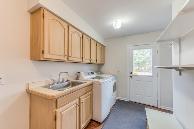 laundry room featuring dark carpet, cabinets, washer and clothes dryer, and sink