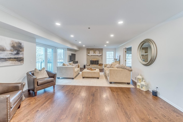 living room featuring crown molding, a fireplace, and light hardwood / wood-style flooring