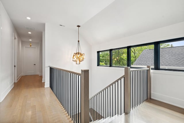 hallway with recessed lighting, an upstairs landing, wood finished floors, a chandelier, and baseboards