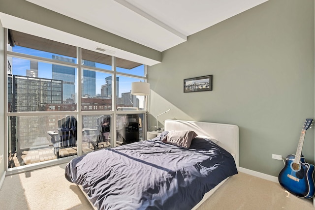 bedroom with floor to ceiling windows and carpet flooring