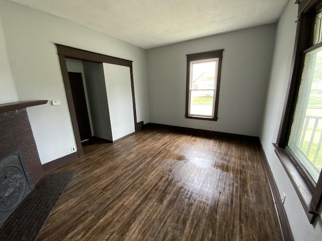 interior space with a fireplace, plenty of natural light, and dark hardwood / wood-style floors