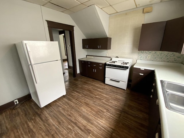 kitchen featuring dark wood-type flooring, dark brown cabinetry, sink, a paneled ceiling, and white appliances