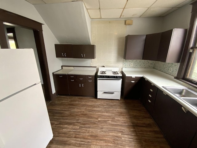 kitchen featuring sink, tasteful backsplash, dark brown cabinets, dark hardwood / wood-style flooring, and white appliances